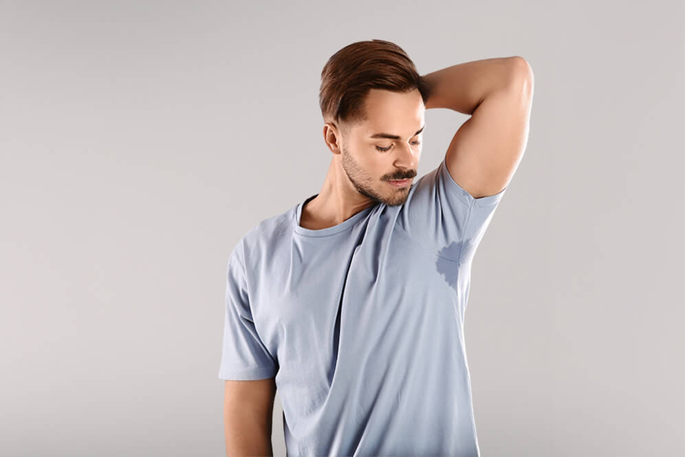 Mann mit Schweißflecken auf dem T-shirt - miraDry ® – Therapie gegen übermäßiges Schwitzen | MVZ Die HautTypen GmbH, Merzhausen